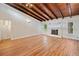 Spacious living room with hardwood floors, a cozy fireplace, and high ceilings with wood beams at 609 Redwood Drive Dr, Woodstock, GA 30189