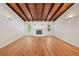 Spacious living room with hardwood floors, a cozy fireplace, and high ceilings with wood beams at 609 Redwood Drive Dr, Woodstock, GA 30189