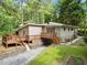 Lovely rear view with an expansive deck, complemented by lush greenery and mature trees at 609 Redwood Drive Dr, Woodstock, GA 30189
