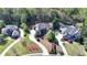 Aerial view of three homes in a neighborhood with mature trees, landscaping, and driveways at 10125 Brixton Pl, Suwanee, GA 30024