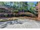 A backyard featuring a brick patio, tiered landscaping, and lush greenery at 10125 Brixton Pl, Suwanee, GA 30024