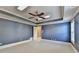 Bedroom with neutral carpet, and blue walls, enhanced by a tray ceiling and bright, natural lighting at 10125 Brixton Pl, Suwanee, GA 30024