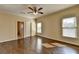 Bedroom featuring wood floors, a ceiling fan, and an adjacent bathroom for comfort and convenience at 10125 Brixton Pl, Suwanee, GA 30024