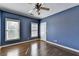 Well-lit bedroom featuring hardwood floors, a ceiling fan, and a window with natural light at 10125 Brixton Pl, Suwanee, GA 30024