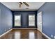 Comfortable bedroom with a ceiling fan, hardwood floors, natural light from two windows, and a closet at 10125 Brixton Pl, Suwanee, GA 30024