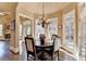 Elegant dining room with a round table, chandelier, and multiple windows, creating a bright and inviting space for meals at 10125 Brixton Pl, Suwanee, GA 30024