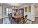 Formal dining room with chandelier, wainscoting, and plantation shutters at 10125 Brixton Pl, Suwanee, GA 30024