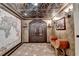 Elegant entryway featuring intricate ceiling details, a world map, and double doors leading to the wine cellar at 10125 Brixton Pl, Suwanee, GA 30024