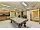 Spacious game room featuring a billiard table, wet bar with granite countertop, and cozy seating area with natural lighting at 10125 Brixton Pl, Suwanee, GA 30024