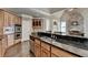 This kitchen features black countertops, stainless steel appliances and custom wood cabinets at 10125 Brixton Pl, Suwanee, GA 30024