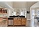 Open kitchen with stone fireplace view, custom wood cabinets, stainless steel dishwasher at 10125 Brixton Pl, Suwanee, GA 30024