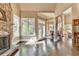 Spacious living room with a stone fireplace, large windows, and dark hardwood floors, providing a cozy and inviting atmosphere at 10125 Brixton Pl, Suwanee, GA 30024