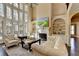 Open living room with floor-to-ceiling windows, fireplace, and neutral decor at 10125 Brixton Pl, Suwanee, GA 30024