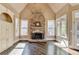 Cozy living space with hardwood floors, stone fireplace, and sunlit windows for natural lighting at 10125 Brixton Pl, Suwanee, GA 30024