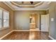Bright main bedroom with large windows, hardwood floors, and an ensuite bathroom with a large vanity at 10125 Brixton Pl, Suwanee, GA 30024