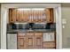 Detailed wet bar area featuring custom cabinets, granite countertop, sink, mini fridge, and a beverage cooler at 10125 Brixton Pl, Suwanee, GA 30024