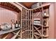 A close up view of the wine cellar's custom wooden racks, bottle display, and marble countertop at 10125 Brixton Pl, Suwanee, GA 30024