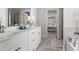Bright primary bathroom with double sinks, white cabinets and a walk-in closet at 242 Crestbrook Ln, Dallas, GA 30157