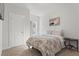 Neutral bedroom with a patterned comforter, window with curtains, and end table at 242 Crestbrook Ln, Dallas, GA 30157