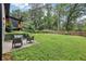 Backyard view showcasing mature trees, well-manicured lawn, patio space and a guest house at 3356 Thornewood Dr, Atlanta, GA 30340