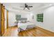 Bright bedroom featuring hardwood floors, a ceiling fan, and barn-style closet doors at 3356 Thornewood Dr, Atlanta, GA 30340