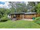 Exterior showcasing a manicured lawn, modern covered porch, carport and lush greenery surrounding the home at 3356 Thornewood Dr, Atlanta, GA 30340
