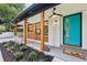 Inviting covered front porch with teal door, modern lighting, and wood accents at 3356 Thornewood Dr, Atlanta, GA 30340