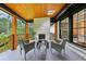 Cozy porch with wood ceiling, fireplace, comfortable seating, and views of the surrounding nature at 3356 Thornewood Dr, Atlanta, GA 30340