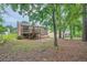 Backyard featuring a two-story home with a wooden deck and stairs leading to the yard at 4470 Hopkins Lake Nw Dr, Duluth, GA 30096