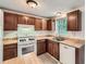 Bright kitchen with white appliances, wood cabinets, and a stainless steel sink at 4470 Hopkins Lake Nw Dr, Duluth, GA 30096