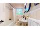 Bathroom with a shower/tub combo, white tiles, a mirror, and a pedestal sink at 773 N Superior Ave, Decatur, GA 30033