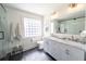 Bathroom with a double vanity, marble countertop, a glass block window, and a glass shower at 1164 Baylor Nw St, Atlanta, GA 30318