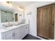 Bathroom featuring double vanity, marble countertop, glass shower, and a wood door at 1164 Baylor Nw St, Atlanta, GA 30318