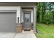 Close up of a gray door with glass panes, brick trim and the house number 153 at 153 Witter Way, Woodstock, GA 30188