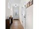 Inviting hallway with hardwood floors, white trim, and access to the front door and garage at 153 Witter Way, Woodstock, GA 30188