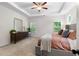 The primary bedroom boasts a dresser with a large mirror, two large windows, and a ceiling fan at 153 Witter Way, Woodstock, GA 30188