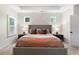 This primary bedroom features a large bed, side tables with lamps and two windows that let in ample light at 153 Witter Way, Woodstock, GA 30188