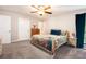 Carpeted bedroom with ceiling fan, and a large bed with colorful floral bedding and an adjacent nightstand at 2022 Ramblewood Ne Ct, Marietta, GA 30062