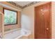 Bathroom showcasing a soaking tub with wood trim and large window at 2088 Blackberry Ln, Auburn, GA 30011