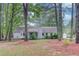 Exterior view of a single-story home surrounded by tall trees in the backyard at 2088 Blackberry Ln, Auburn, GA 30011