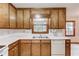 Classic kitchen featuring wood cabinets, white appliances, and a window over the sink, blending functionality with style at 2088 Blackberry Ln, Auburn, GA 30011