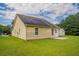 The backyard features a well-maintained lawn and a charming, light yellow home exterior with a back patio at 3673 Jervis Ct, Rex, GA 30273