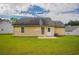 A well-kept lawn surrounds the house, complementing its light yellow exterior and back patio at 3673 Jervis Ct, Rex, GA 30273