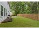Well-maintained backyard with lush green grass, a charming wooden fence, and a patio area for outdoor enjoyment at 4266 Suwanee Brook Ct, Buford, GA 30518