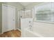Bright bathroom featuring a tub and shower combination, a large window, and modern fixtures at 4266 Suwanee Brook Ct, Buford, GA 30518