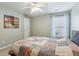 This cozy bedroom has a ceiling fan, a window with natural light, and neutral-colored walls at 4266 Suwanee Brook Ct, Buford, GA 30518
