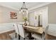 Bright dining room with wood floors, wainscoting and view of living room at 4266 Suwanee Brook Ct, Buford, GA 30518