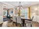 Dining room with chandelier, hardwood floors, wainscoting, and access to living room with blue couch at 4266 Suwanee Brook Ct, Buford, GA 30518