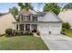 Charming two-story home featuring a welcoming front porch, two-car garage, and a well-manicured lawn at 4266 Suwanee Brook Ct, Buford, GA 30518