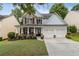 Charming two-story home featuring a welcoming front porch, two-car garage, and a well-manicured lawn at 4266 Suwanee Brook Ct, Buford, GA 30518